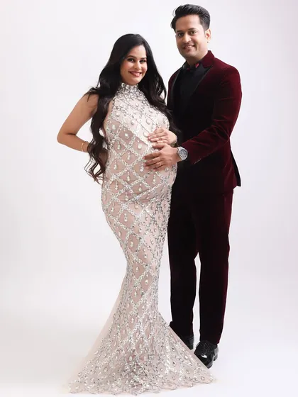 A classic, smiling portrait of the glamorous couple. They stand together, radiating happiness and love in their stunning formal wear.