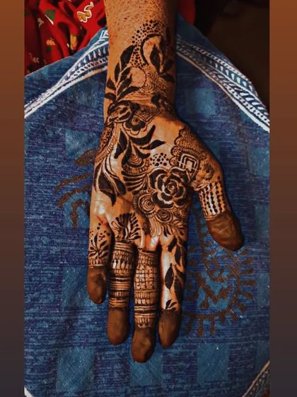 This is a pure Arabic style with a focus on bold, dark shading. The design features a large floral and leaf pattern that sweeps across the hand, making a dramatic statement.