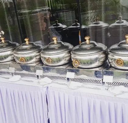 A beautiful outdoor terrace setup for a corporate lunch for Sudha Carpets. The hammered-steel chafing dishes and fresh floral arrangements elevate the dining experience.