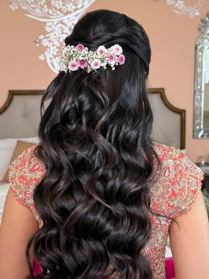 The full back view of the floral half-up style, with soft waves cascading down.