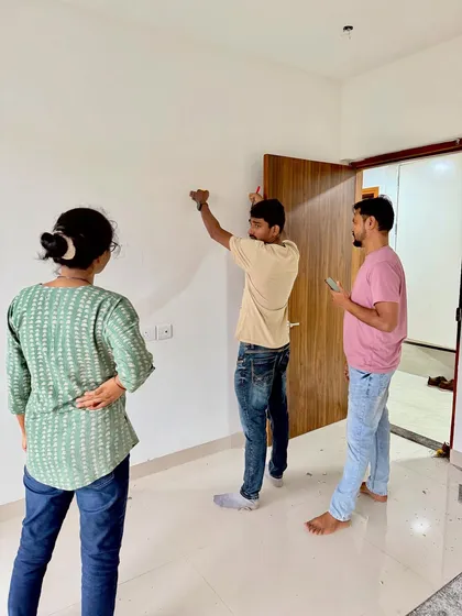 On-site with clients, measuring and marking the wall for furniture placement. Precision from the start is essential.