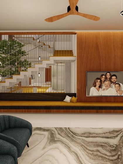 In this family room, we combined a comfortable seating area with a built-in media unit against a warm wood-paneled wall. The design includes an open view of the staircase, which features an integrated planter, bringing a touch of green indoors.