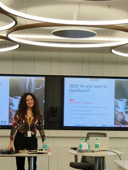 A confident pose in front of my presentation. I aim to embody the principles of strong presence and confident communication that I teach in my workshops.