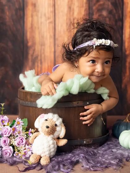 Peeking out of a rustic barrel, this six-month-old is full of playful energy. We use props to create fun and engaging scenes for our milestone shoots.