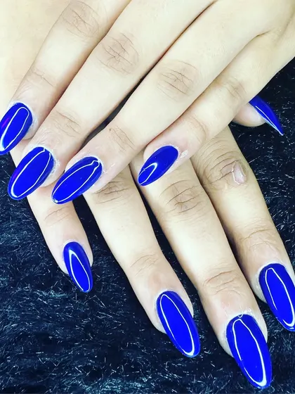 A simple color that makes a big impact. This set features a vibrant, electric blue gel polish on long, oval-shaped nails for a clean, glossy, and eye-catching look.