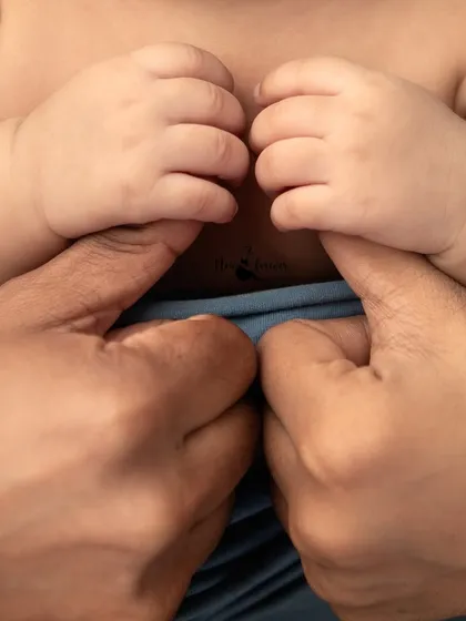 A parent's hands gently hold their newborn's tiny fingers. This powerful image symbolizes the immediate and unbreakable bond between parent and child.