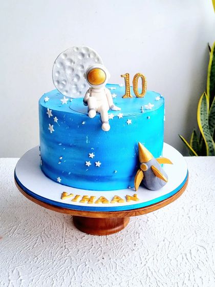 This space-themed cake features a hand-painted galaxy effect on the buttercream. I also teach how to sculpt a cute astronaut, a rocket, and a textured moon topper from fondant.