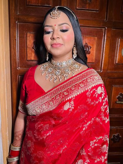 My beautiful bride Kavya in a classic red saree for her wedding. The makeup is soft and defined, with a focus on her eyes and a radiant complexion.