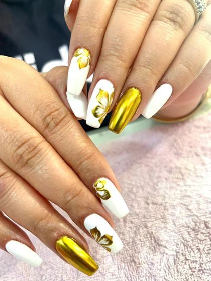 A striking combination of solid white and gold chrome on coffin nails, with hand-painted gold butterflies for an elegant touch.