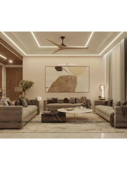 This view highlights the clean lines and modern elegance of the drawing room. The neutral color palette is punctuated by abstract art and layered lighting from the ceiling, creating a calm and sophisticated environment for relaxation and conversation.