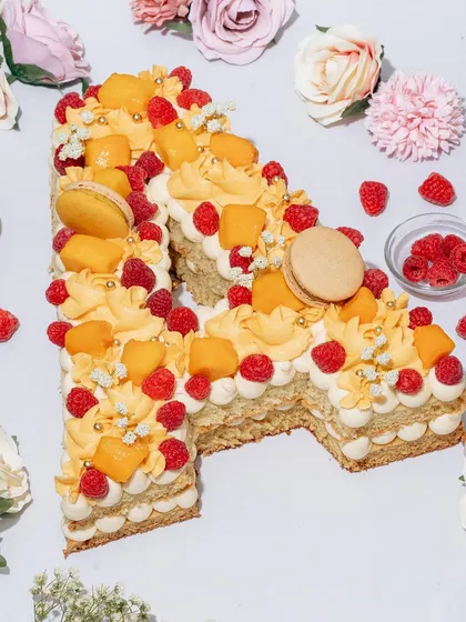This beautiful monogram cake is a work of art. We styled it with fresh flowers and fruits that complement its colors, creating a soft, romantic, and celebratory image perfect for a special occasion.