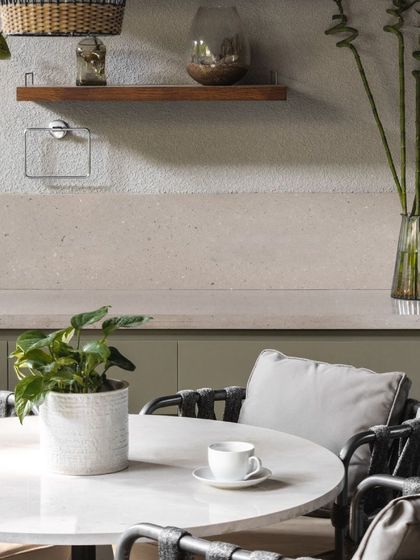 On the outdoor deck, a simple dining setup with an open pantry makes for perfect alfresco meals. The muted tones allow the surrounding greenery to stand out.