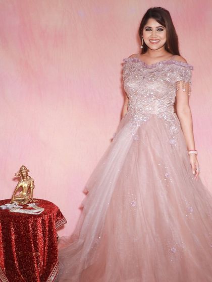 Live your princess moment. This cold-shoulder pastel pink ball gown is covered in delicate glitter and embroidery, making it a dream come true for any engagement or reception.