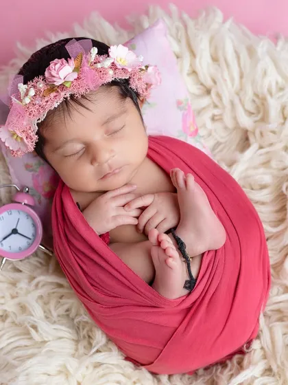 The 'tucked in' pose with tiny feet peeking out is always a favorite for parents.