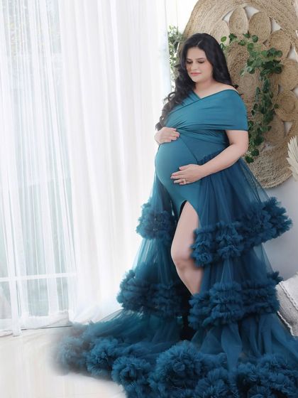A moment of quiet reflection by the window. The deep teal ruffled gown adds a splash of rich color and texture to this beautifully lit portrait.