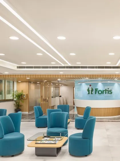 A wider view of the Fortis Ludhiana waiting lounge, showing how linear lighting and a clean ceiling design contribute to a sense of order and spaciousness. The layout ensures comfortable circulation and a relaxed patient experience.