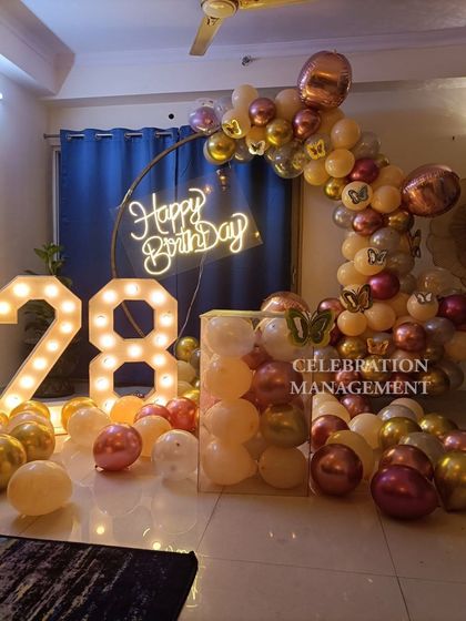 The 'Happy Birthday' neon sign provides a perfect focal point within the stylish balloon arch.