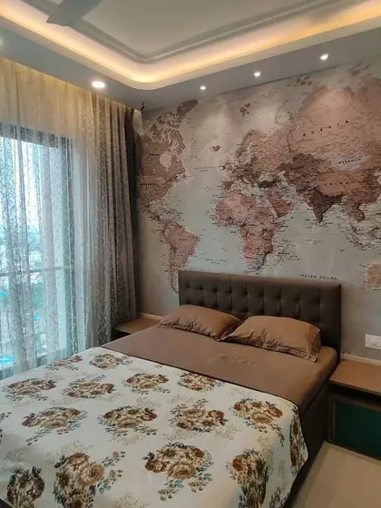 Here you can see how natural light interacts with the travel-themed bedroom. The sheer curtains diffuse the daylight, creating a soft glow that enhances the details of the world map wallpaper and makes the entire room feel airy and connected to the outdoors.