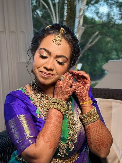 A candid moment of this Iyer bride, her soft gold eyes and rosy nude lip makeup looking beautiful as she adjusts her jewellery.