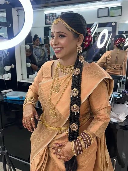 The finished look: a stunning traditional braid with temple-style accessories, a 'matha patti', and a happy smile.