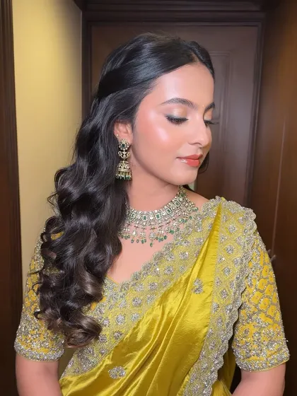 A close-up of the client's look, showing her glowing makeup and the soft waves of her hair.