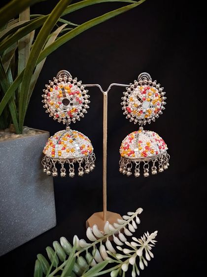 Our adorable multicolour mirror work jhumka, displayed on a stand to show its full design and craftsmanship.