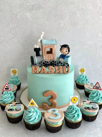 A choo-choo train cake for Hashu's 3rd birthday. This cute set includes a main cake with a train topper and matching themed cupcakes.