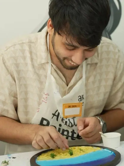 A participant smiles as he adds details to his resin beach art during a corporate event. It's a fun and creative break from the usual workday.