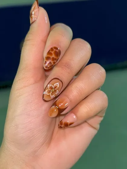 This design features a warm, earthy palette with hand-painted animal prints and a delicate floral accent. The mix of patterns creates a stylish and cohesive look.