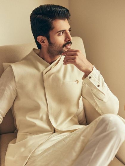 This thoughtful pose shows off the beautiful cut of the waistcoat and the relaxed elegance of the overall look.