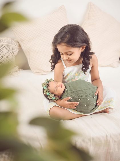 A beautiful moment of connection. We gently guide older siblings to interact with the new baby to capture these authentic, heartwarming photos.