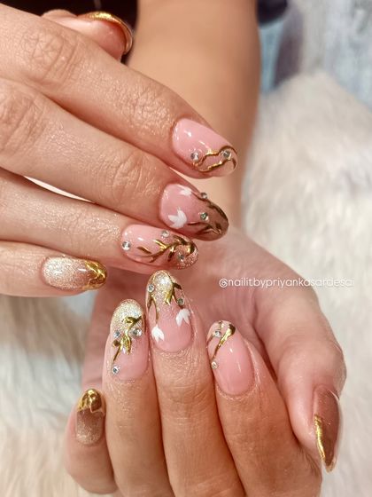 Where nail care meets luxury. This stunning set features soft nude tones, delicate gold accents, and detailed, hand-painted white flowers, all finished with expert care.
