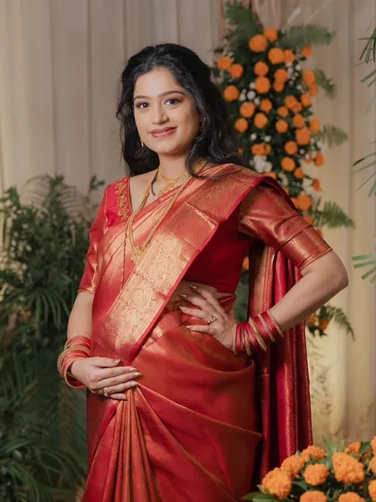A beautiful and traditional look for a baby shower. Draped in a classic red silk saree, her makeup is kept minimal and glowing to celebrate this special milestone.