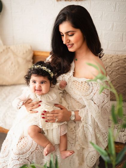A close-up capturing the sweet smile of the baby and the loving gaze of her mother.