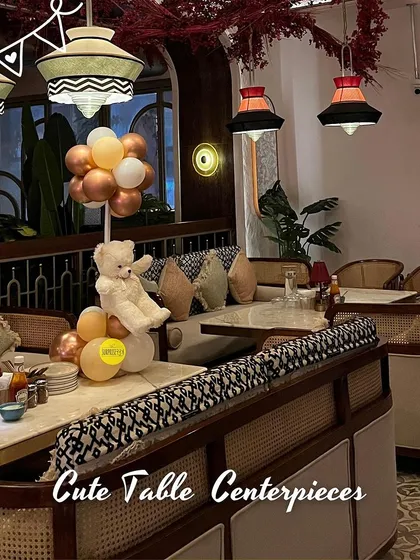 A cute teddy bear centerpiece sitting on a restaurant table. Even small details like this can add a touch of charm and tie together the theme for a baby shower or a child's birthday party.