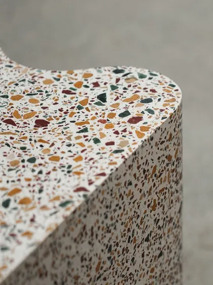 Close-up details of the custom terrazzo bookshelf, highlighting the smooth curves and the beautiful texture of the multi-colored stone chips.