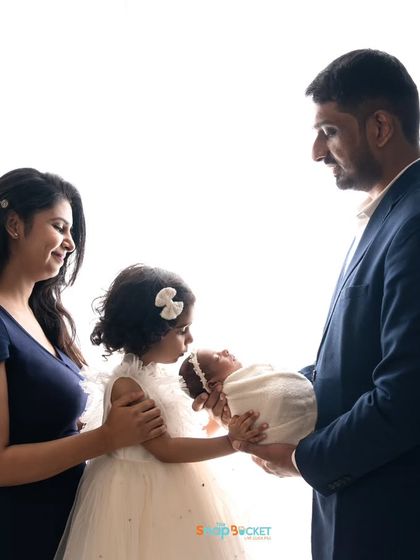 The whole family admiring their newest member. I love creating classic, bright portraits like this that celebrate your complete family unit.