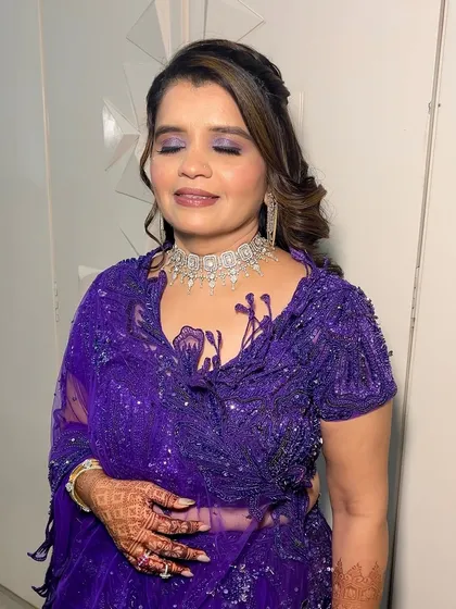 A close-up with eyes closed, this shot perfectly displays the purple and shimmer eyeshadow blend. It's a great example of how to incorporate color into an evening look.