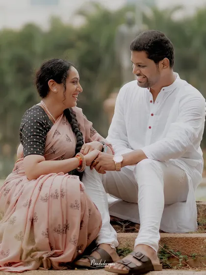 A relaxed moment of a couple sitting and chatting in a park in Mysore, showcasing a more casual and natural interaction.