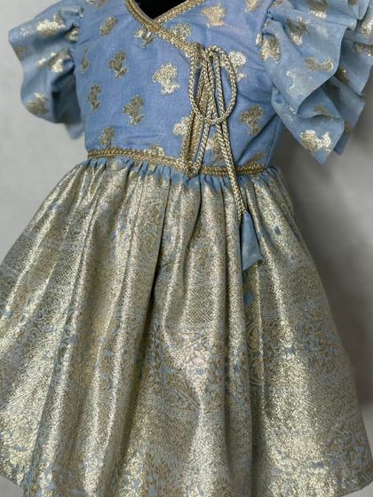 A close-up of the Mogra blue dress, highlighting the angrakha-style tie and the pretty floral pattern on the bodice.