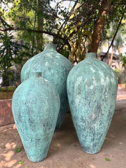 The 'Kembung' trio in a rustic teal finish, shown in an outdoor setting where they blend beautifully with nature.