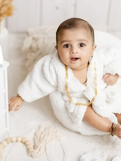 A curious look from our boss baby, reaching out from his chair in the middle of his luxurious setup.