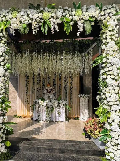 We believe a beautiful beginning sets the tone for the entire event. This grand entrance arch, crafted with a dense arrangement of white carnations, roses, and hanging wisteria, provides an elegant and memorable welcome for your guests.