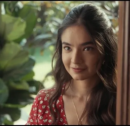 A shot of the female lead from the film. Her look is natural and fresh, with a simple red floral dress that adds a touch of romance to the scene.
