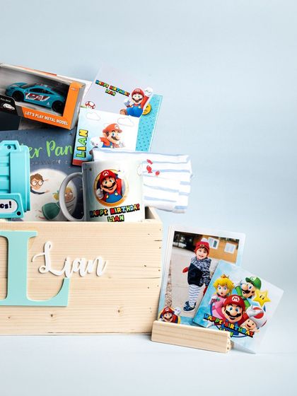 A fun Super Mario themed birthday hamper for a young boy named Lian. The wooden crate is personalized with his initial and name and filled with toys and treats.