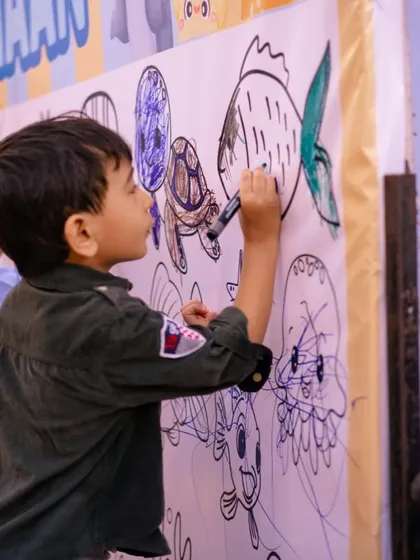 Another angle of the popular coloring wall, showing a young boy carefully coloring in a turtle. It's a wonderful, calm activity for kids of all ages.