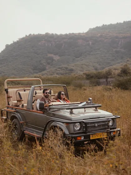 An adventurous pre-wedding shoot in Ranthambore, with the couple enjoying a private moment in a safari jeep amidst the wild, rustic landscape.