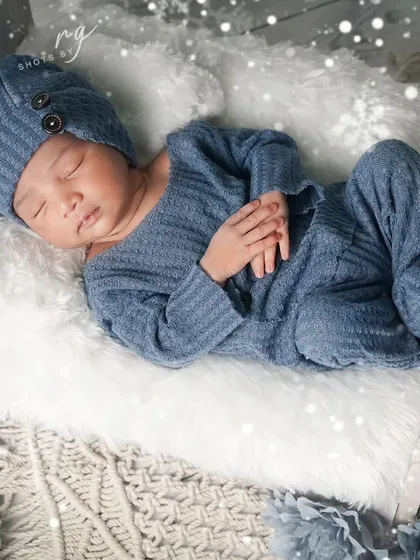 "Baby it's cold outside." A 5-day-old newborn in a cozy blue knit outfit, perfect for a winter-themed shoot, complete with a teddy bear and snowy effects.