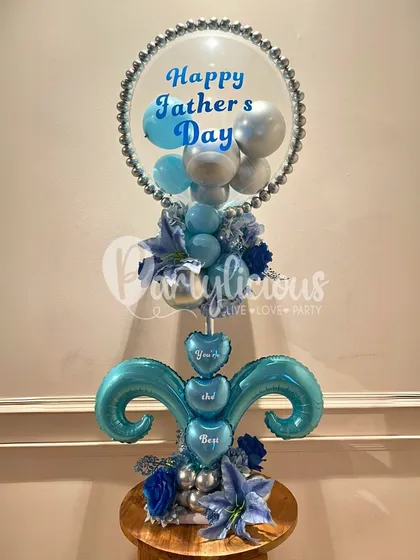 A beautiful and intricate Father's Day balloon bouquet in shades of blue and silver. The custom message "You're the Best" on the smaller hearts adds a sweet, personal touch.