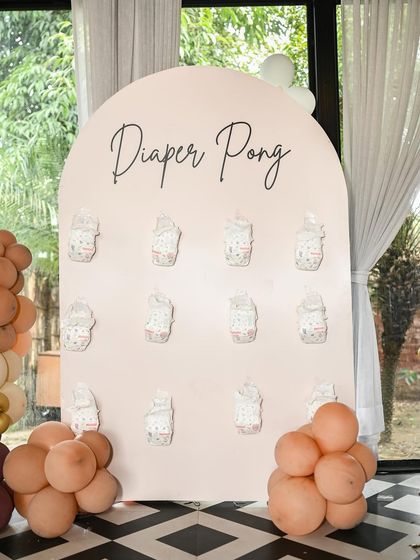 A chic 'Diaper Pong' game board in blush pink with elegant script. I ensure even the games look stylish and cohesive with the overall event decor.